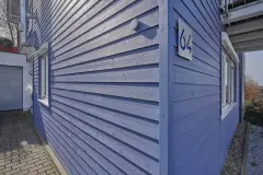 Detailansicht eines Hauses mit hellblauer Holzfassade