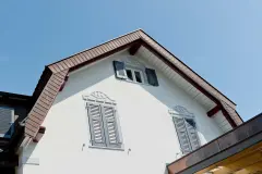 Detailansicht eines Hauses mit grauen Fensterläden Deko-Elementen